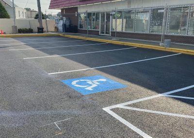A Quick Mart store with an empty parking lot and a visible handicapped parking space in front.